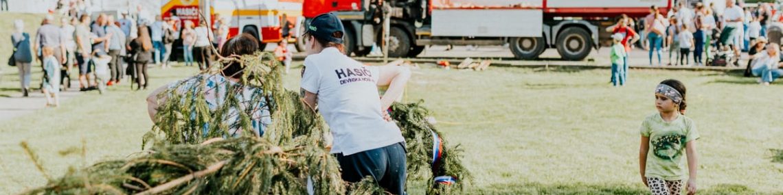 A lively outdoor community event featuring fire trucks, families, and a festive atmosphere.